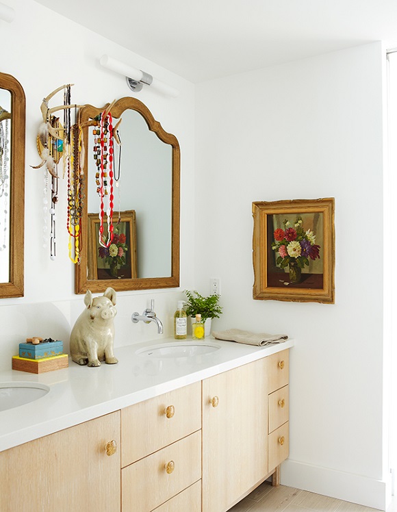 Banheiro com paredes e bancada da pia brancas e balcão e espelhos em madeira,