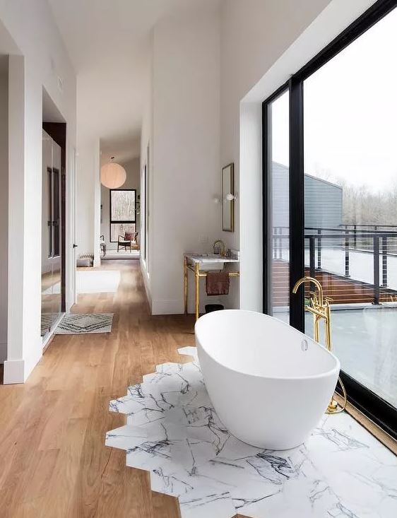 Banheiro com piso que combina mármore e madeira.