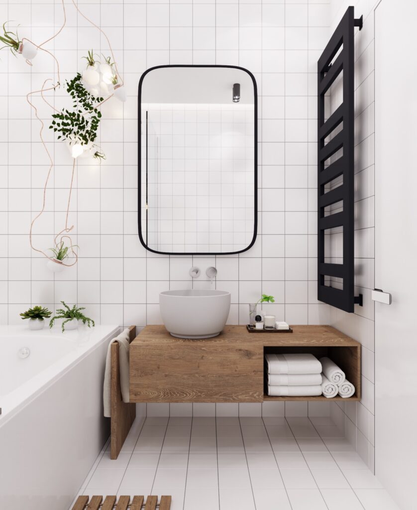 Banheiro branco com bancada de pia em madeira marrom.