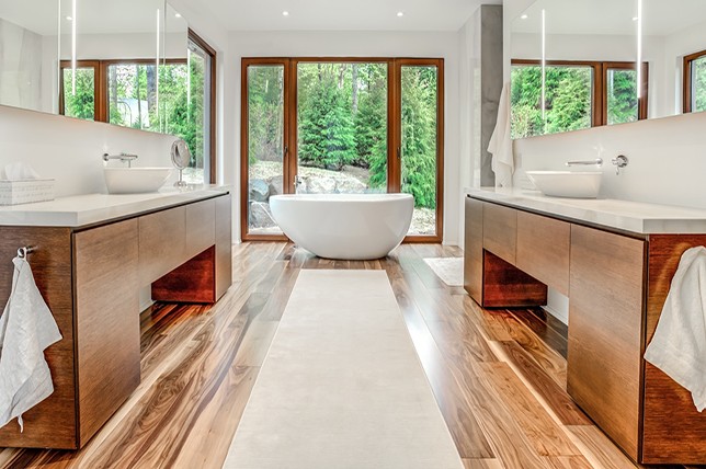 Banheiro com piso e bancadas de madeira em estilo contemporâneo.