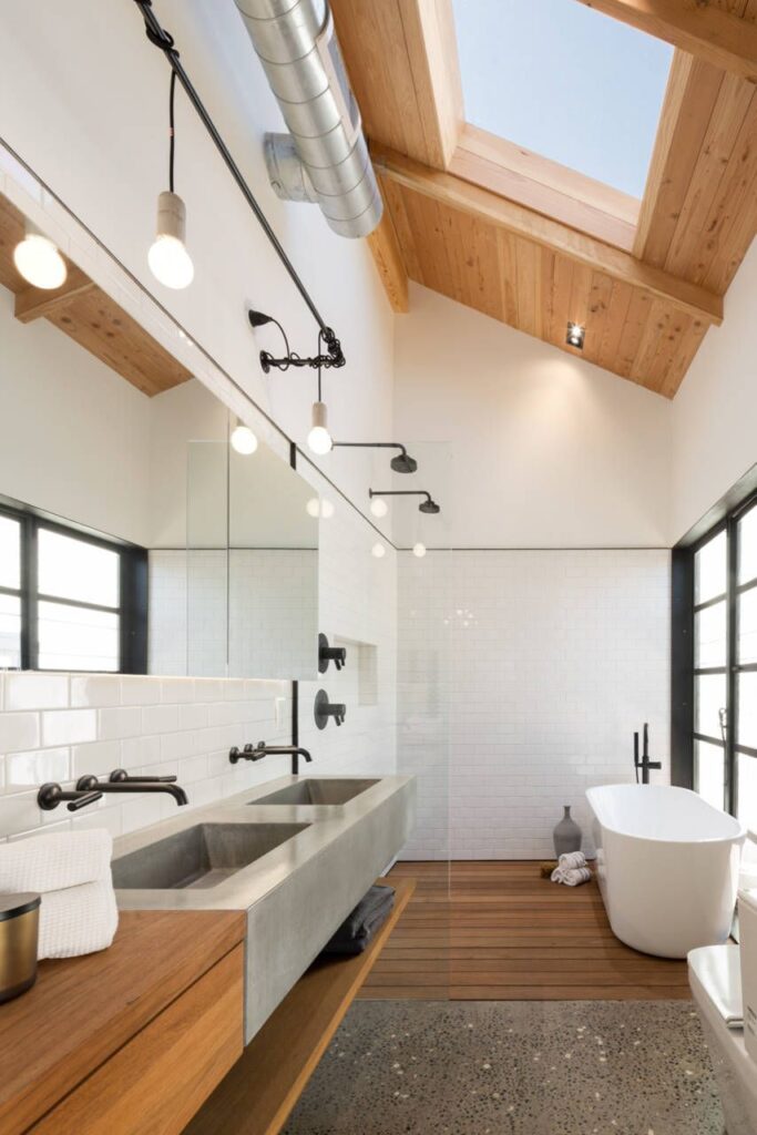 Banheiro com tubos expostos e detalhes em madeira.