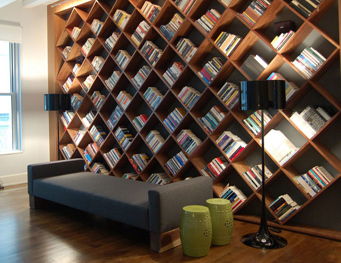 Estante para livros com nichos na parede toda.