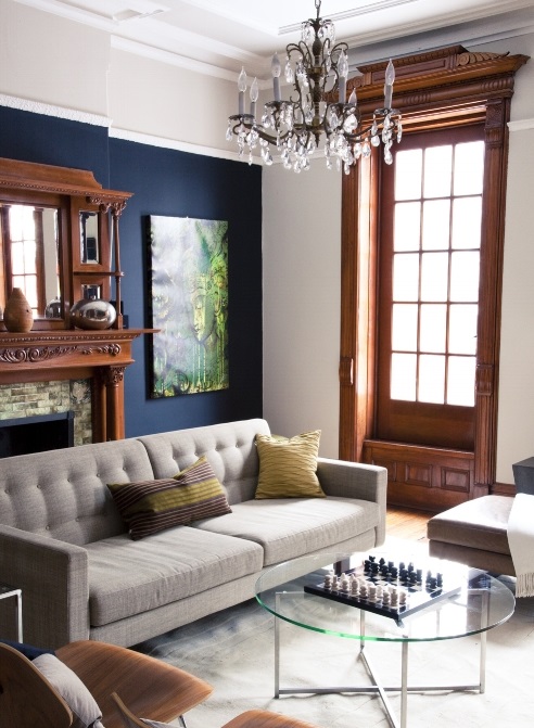 Sala de estar com parede azul-marinho combinando com detalhes em madeira.