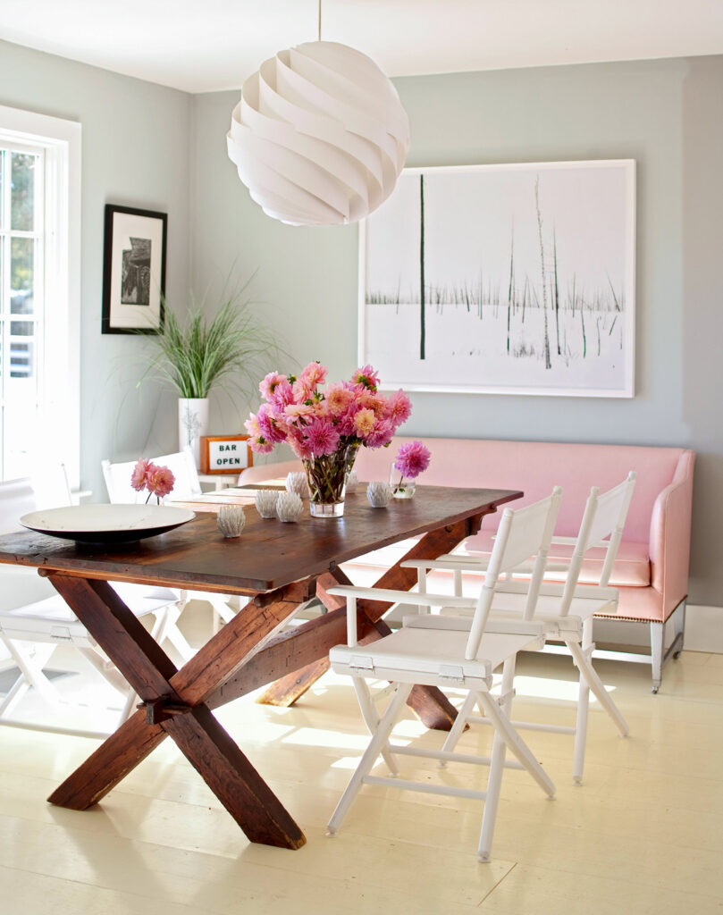 Mesa de madeira escura combinando com tons claros de amarelo, rosa, verde e branco.