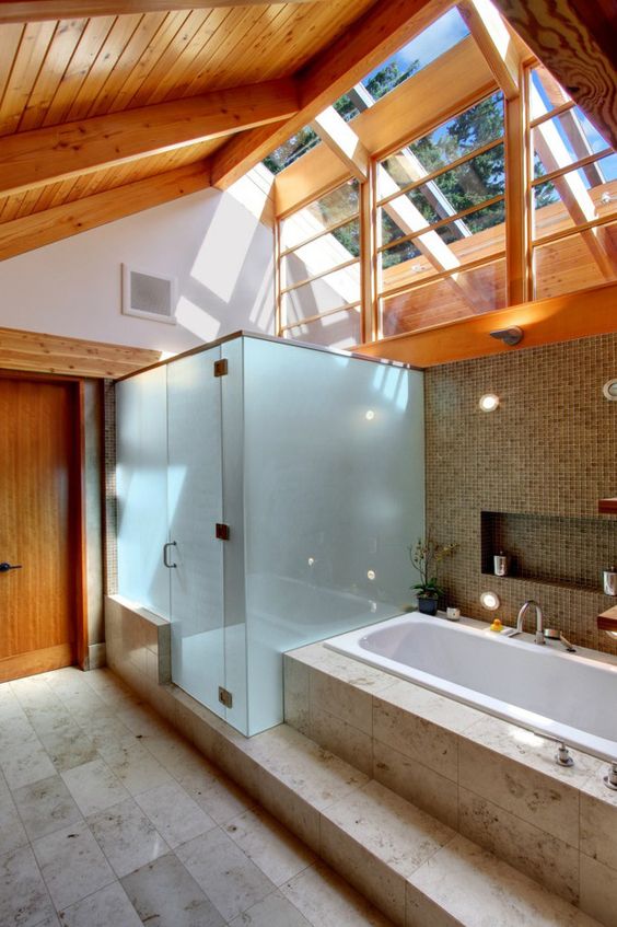 Banheiro com claraboia de ventilação e teto de madeira.